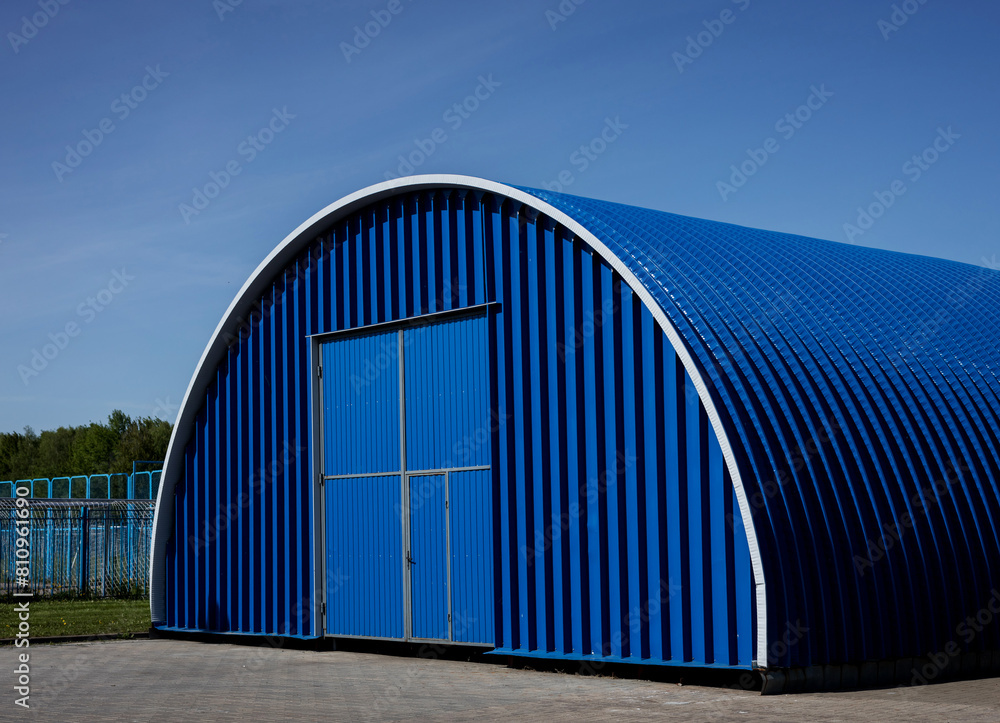 Obraz premium Blue Metal hangar oval against sky