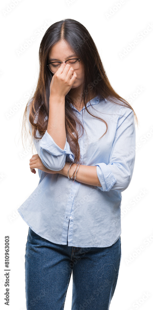 Young asian business woman wearing glasses over isolated background tired rubbing nose and eyes feeling fatigue and headache. Stress and frustration concept. Young asian business woman wearing glasses over isolated background tired rubbing nose and eyes feeling fatigue and headache. Stress and frustration concept.