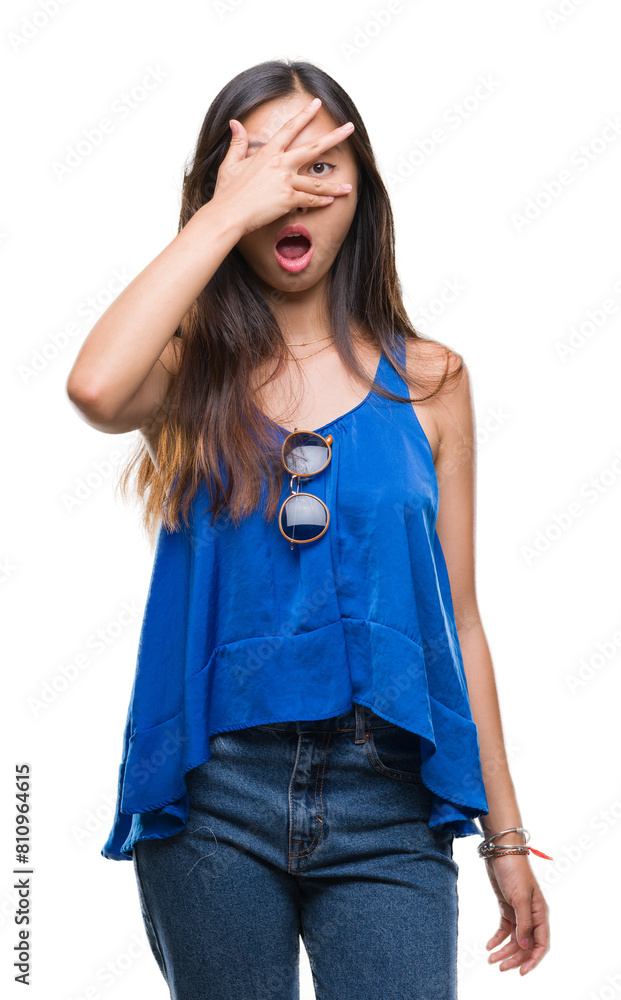 Young asian woman over isolated background peeking in shock covering face and eyes with hand, looking through fingers with embarrassed expression. Young asian woman over isolated background peeking in shock covering face and eyes with hand, looking through fingers with embarrassed expression.