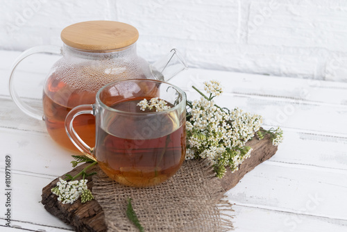 tea in a teapot (decoction)from the leaves and flowers of medicinal yarrow (Achillea) in a cup. Traditional medicine, the collection of useful herbs. Alternative medicine