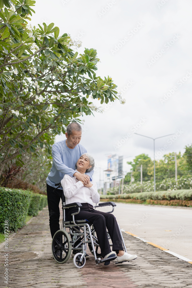 Happy Asian senior couple walking together on a tropical forest path Retired old man and woman having fun and enjoying outdoor travel activities. Vertical image