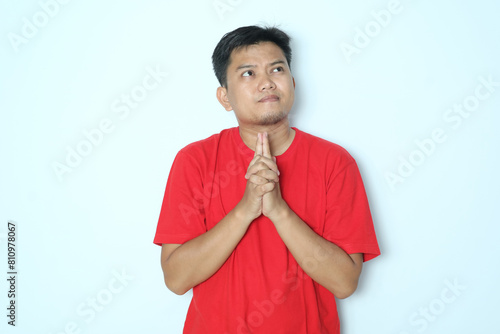 Young Asian man thinking gesture expression with his eyes looking up. Wearing red a shirt photo