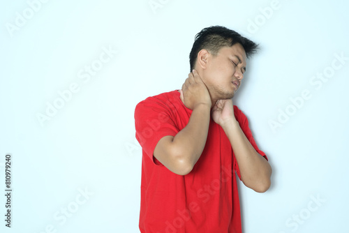 Young Asian man suffering pain of his neck. Wearing red a shirt photo