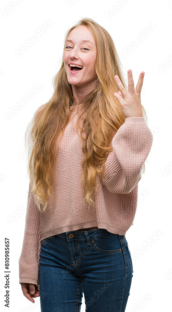 Blonde teenager woman wearing pink sweater showing and pointing up with fingers number three while smiling confident and happy. Blonde teenager woman wearing pink sweater showing and pointing up with fingers number three while smiling confident and happy.