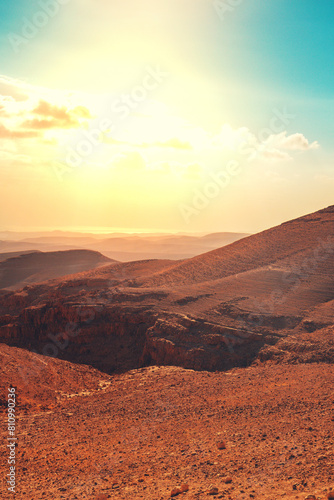 Mountainous desert with colorful cloudy sky. Judean desert in Israel at sunset. Vertical banner