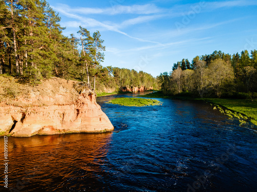 aerial view of the striking red cliffs and lush forests along a curving river Salaca in latvia