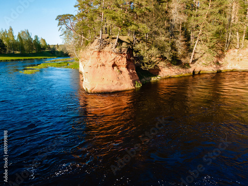 aerial view of the striking red cliffs and lush forests along a curving river Salaca in latvia photo