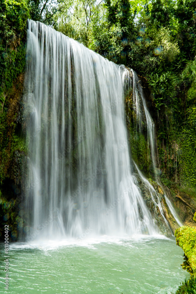 Naklejka premium Vertical long exposure daytime shot of La Caprichosa, a huge waterfall in a stone monastery in Spain. With the water with silk effect as it falls.