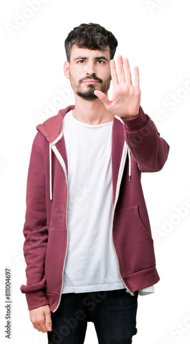 Young handsome man over isolated background doing stop sing with palm of the hand. Warning expression with negative and serious gesture on the face.