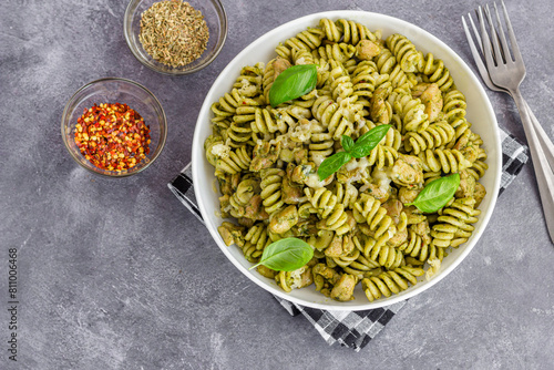 Basil Pesto Chicken Pasta Made with Fusilli, Served with Herbs, Chilli Flakes, and Fresh Basil Leaves