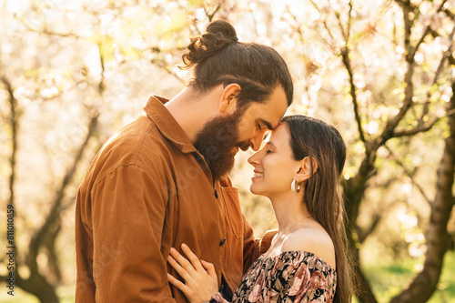 Outdoors portrait of an in love couple touching forehead with eyes closed.