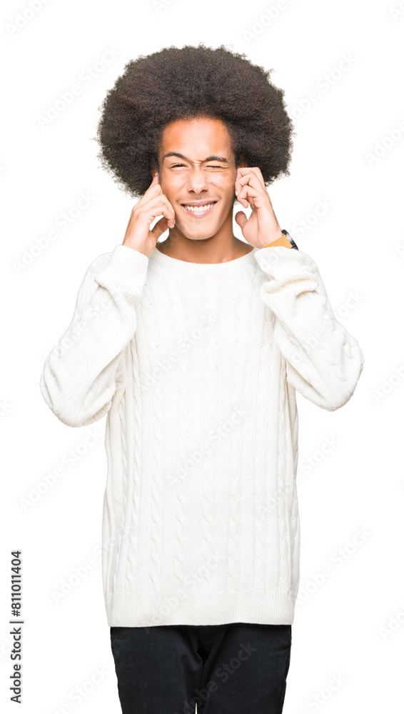 Young african american man with afro hair wearing winter sweater covering ears with fingers with annoyed expression for the noise of loud music. Deaf concept. Young african american man with afro hair wearing winter sweater covering ears with fingers with annoyed expression for the noise of loud music. Deaf concept.