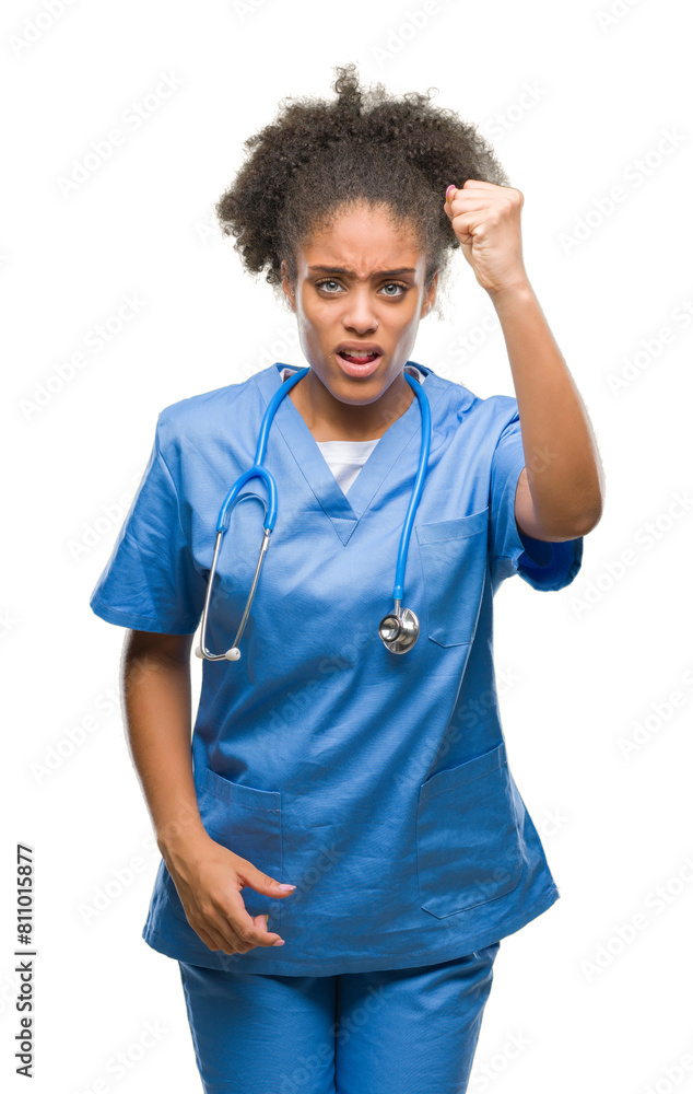Young afro american doctor woman over isolated background angry and mad raising fist frustrated and furious while shouting with anger. Rage and aggressive concept. Young afro american doctor woman over isolated background angry and mad raising fist frustrated and furious while shouting with anger. Rage and aggressive concept.