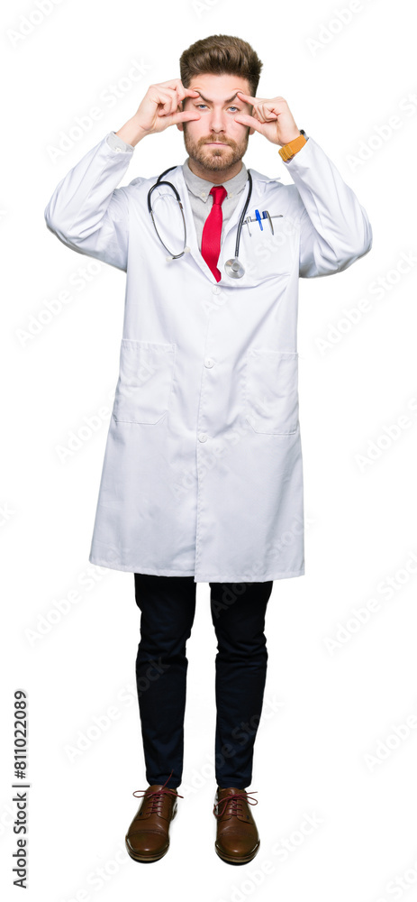 Young handsome doctor man wearing medical coat Trying to open eyes with fingers, sleepy and tired for morning fatigue Young handsome doctor man wearing medical coat Trying to open eyes with fingers, sleepy and tired for morning fatigue