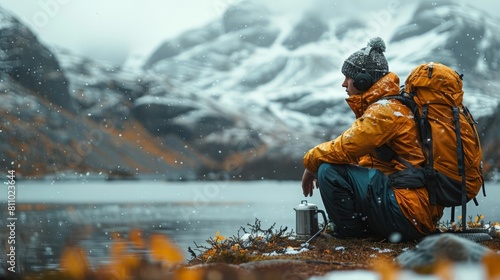 A rugged man is camping outdoors in a wintery setting 