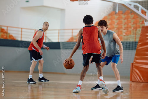 Basketball players in action during match at sports gymnasium.