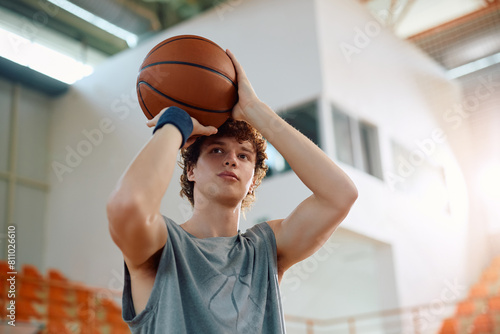 Young basketball player shooting at hoop during sports training.