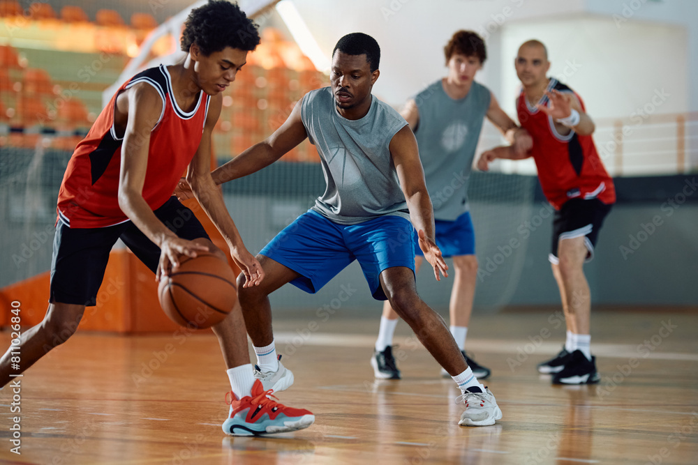 Black defense player trying to block his opponent during basketball match. Black defense player trying to block his opponent during basketball match.