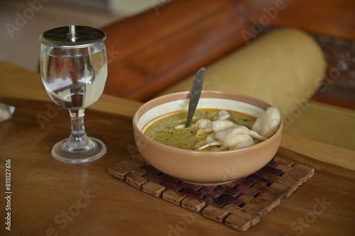 LONTONG SAYUR is famous Indonesian local street food for breakfast. Its consisted of rice cake with mixed vegetable coconut milk curry soup and salty crackers photo