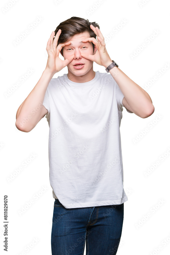 Young handsome man wearing casual white t-shirt over isolated background Trying to open eyes with fingers, sleepy and tired for morning fatigue Young handsome man wearing casual white t-shirt over isolated background Trying to open eyes with fingers, sleepy and tired for morning fatigue