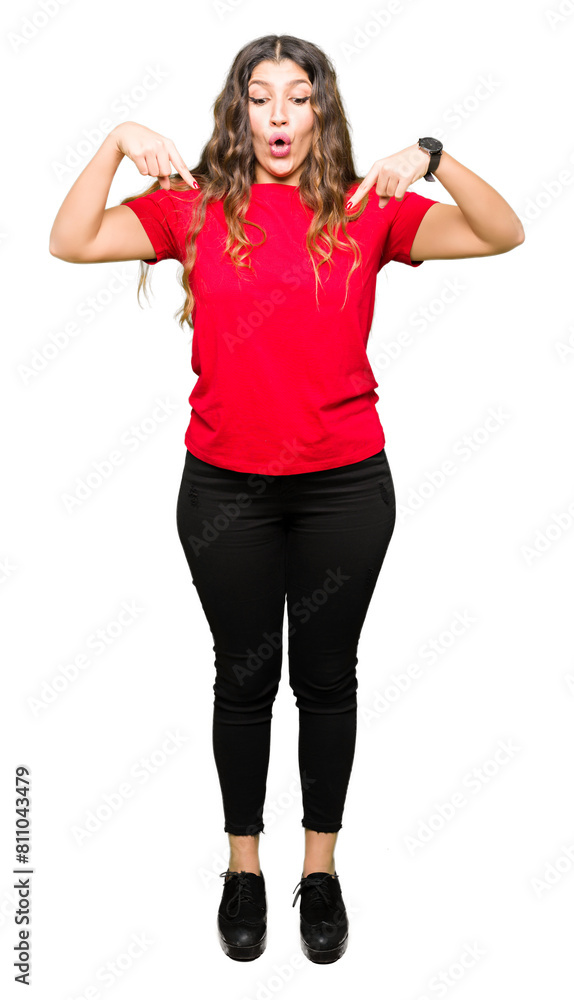 Young beautiful woman wearing casual t-shirt Pointing down with fingers showing advertisement, surprised face and open mouth Young beautiful woman wearing casual t-shirt Pointing down with fingers showing advertisement, surprised face and open mouth