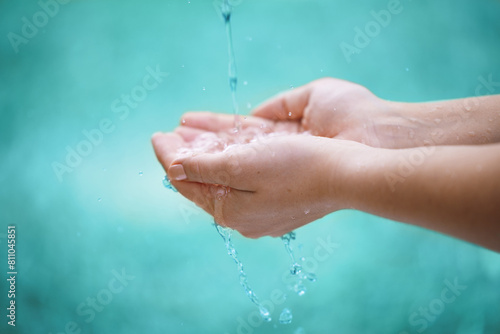 Person, hands and water with drops for natural hydration, hygiene or sustainability on a blue background. Closeup of wet consumer with splash, liquid element or fresh mineral for care, hope or nature