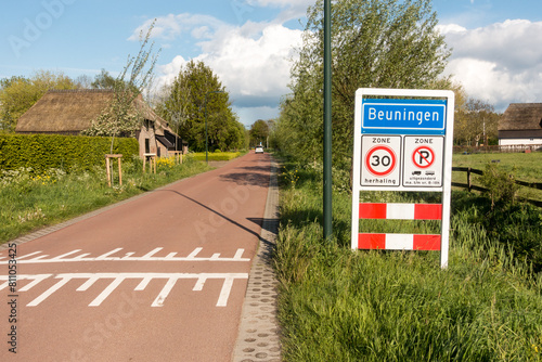 Place name sign for the village of Beuningen, the Netherlands, on a sunny day in spring (also speed limit of 30 km per hour, and no parking for trucks or buses)