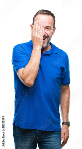 Middle age hoary senior man over isolated background covering one eye with hand with confident smile on face and surprise emotion.