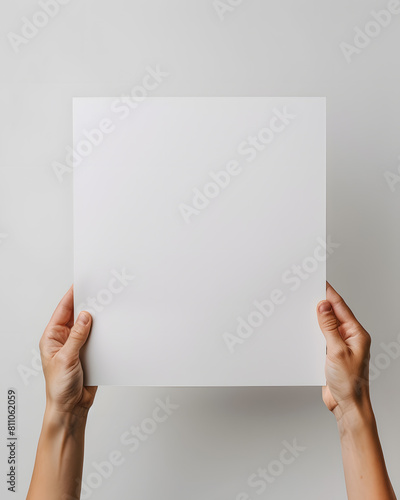 Hands holding blank paper mock up isolated on white background © Oksana