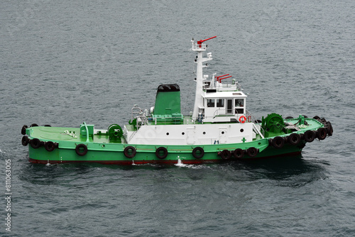 Tug boat navigating in harbor waters photo