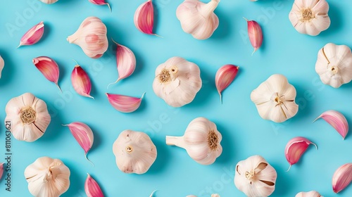 Garlic slices and whole, shot from above, making a fun pattern on a bright pastel color background, magazine cover photo