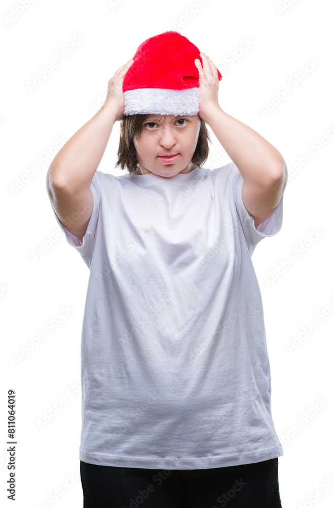 Young adult woman with down syndrome wearing christmas hat over isolated background suffering from headache desperate and stressed because pain and migraine. Hands on head. Young adult woman with down syndrome wearing christmas hat over isolated background suffering from headache desperate and stressed because pain and migraine. Hands on head.