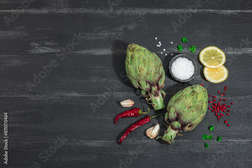 Fresh green artichokes cooking on wooden background. Traditional seasonal ingredients photo