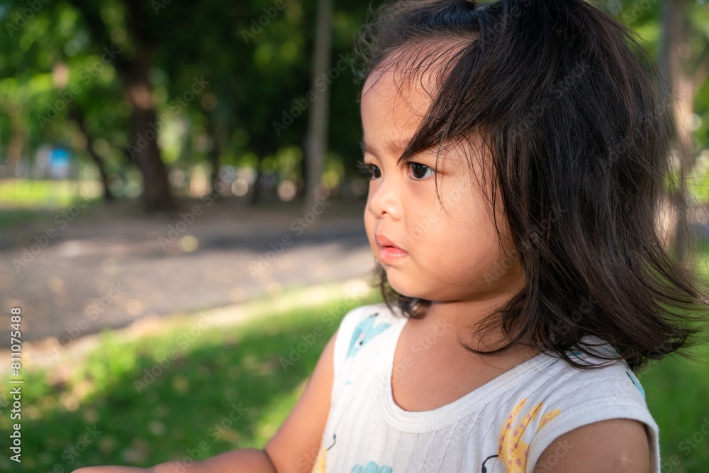 Toddler asian girl enjoying on green meadow grass sunset city park Toddler asian girl enjoying on green meadow grass sunset city park