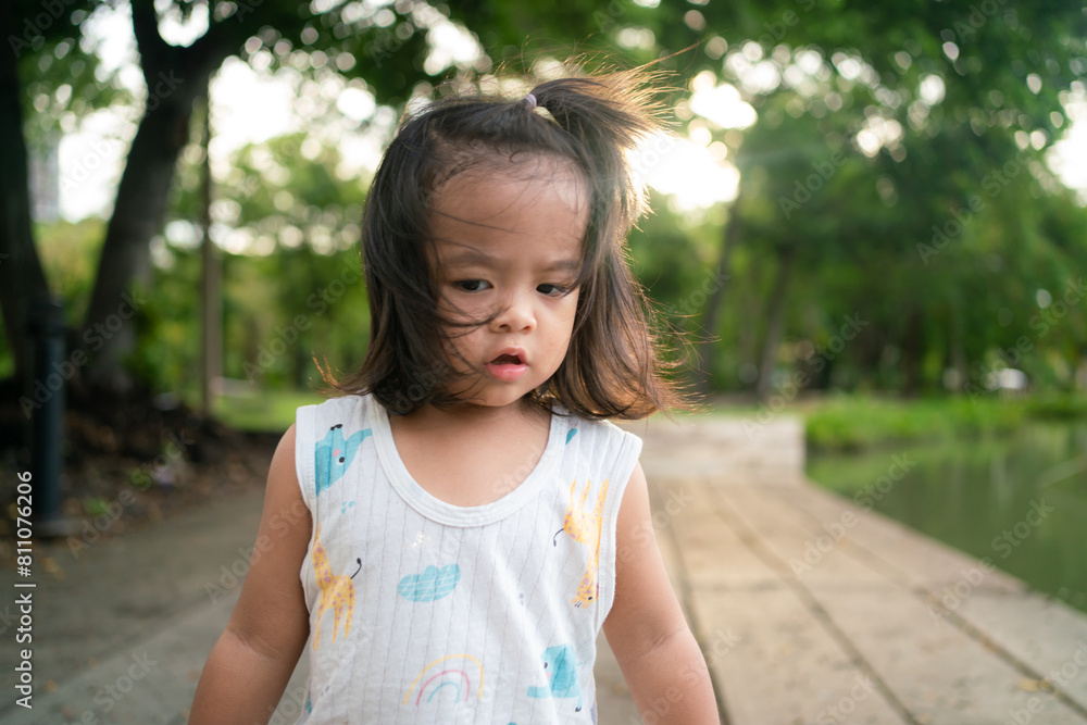 Toddler asian girl enjoying on green meadow grass sunset city park Toddler asian girl enjoying on green meadow grass sunset city park