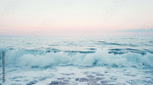 A minimalist shot of serene ocean waves gently lapping against the shore, with soft pastel colors and tranquil atmosphere evoking a sense of peace and serenity. Dynamic and dramati