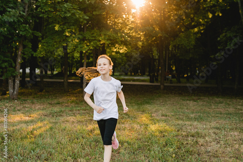 Portrait of smiling athletic tween girl running outdoors. Children sport, accomplishment , healthy active lifestyle concept.