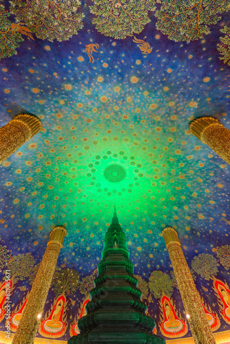 Tall emerald green glass pagoda and ornate roof with Buddhist art inside the Phrarathchamongkhon Stupa at the Wat Paknam (Pak Nam) Phasi Charoen Temple in Bangkok, Thailand.