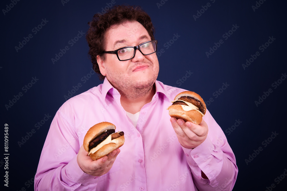 Sports nutrition and healthy lifestyle. Funny fat man and his bad dieting habits. Blue background. Sports nutrition and healthy lifestyle. Funny fat man and his bad dieting habits. Blue background.