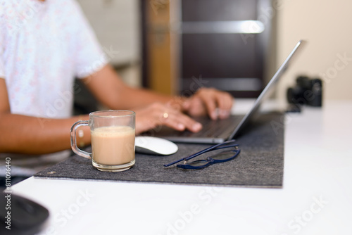 Young woman working at home with a laptop and a cup of coffee