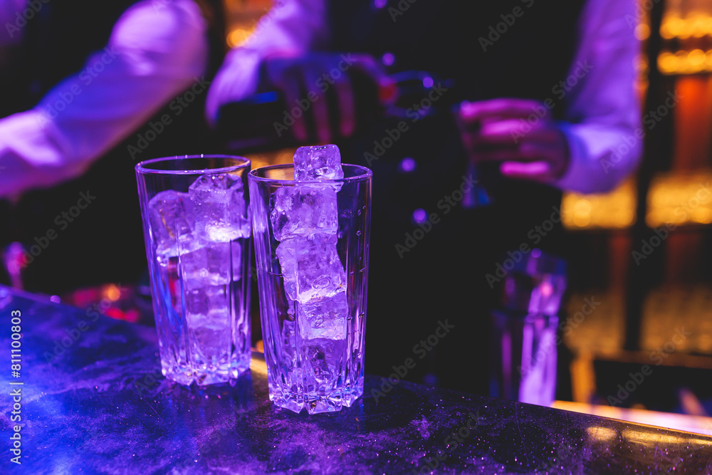 Bartender working, beautiful row line of different coloured liquor alcohol cocktails on a party in a bar, and others on catering banquet on event, barman mixing drinks and beverages in a club Bartender working, beautiful row line of different coloured liquor alcohol cocktails on a party in a bar, and others on catering banquet on event, barman mixing drinks and beverages in a club
