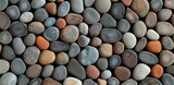 A background of smooth, round pebbles in various colors and sizes arranged neatly together