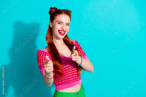 Photo of funky cool lady dressed pink knitted shirt pointing you two fingers emtpy space isolated blue color background