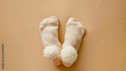 A pair of white socks with fluffy pom poms.