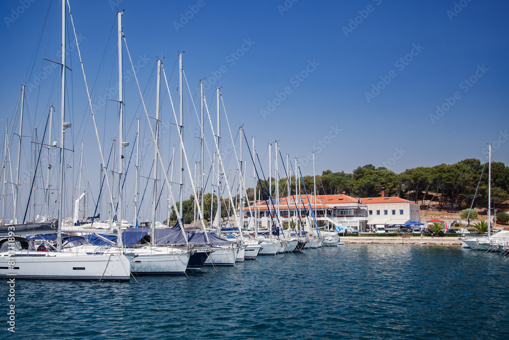 Coastal town and marina with boats and clear blue sky. European travel and vacation concept