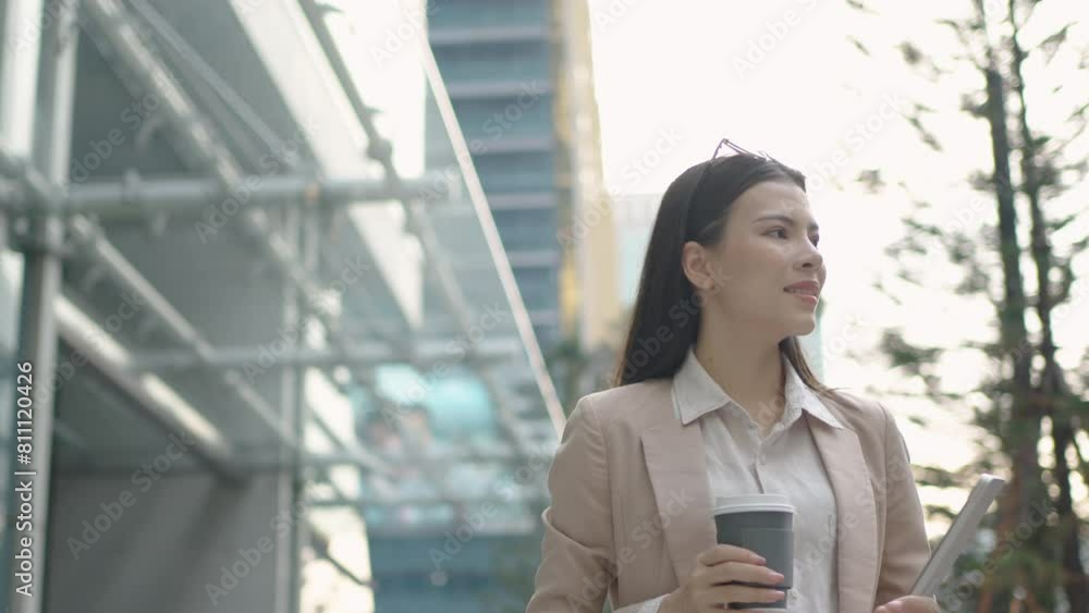 White businesswoman holding a mug of hot coffee walks in the city after work. White businesswoman holding a mug of hot coffee walks in the city after work.