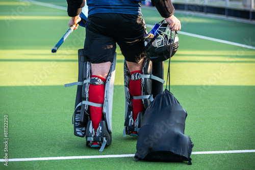 Photography Field hockey theme: A field hockey goalkeeper carrying and wearing Field Hockey Goalie gear Full Set