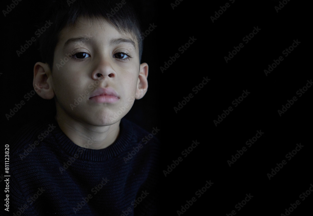 close-up portrait of face of Latino boy facing front looking at camera angry, distressed, with black background. close-up portrait of face of Latino boy facing front looking at camera angry, distressed, with black background.