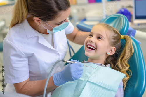 Young woman dentist smiling with little girl patient at clinic