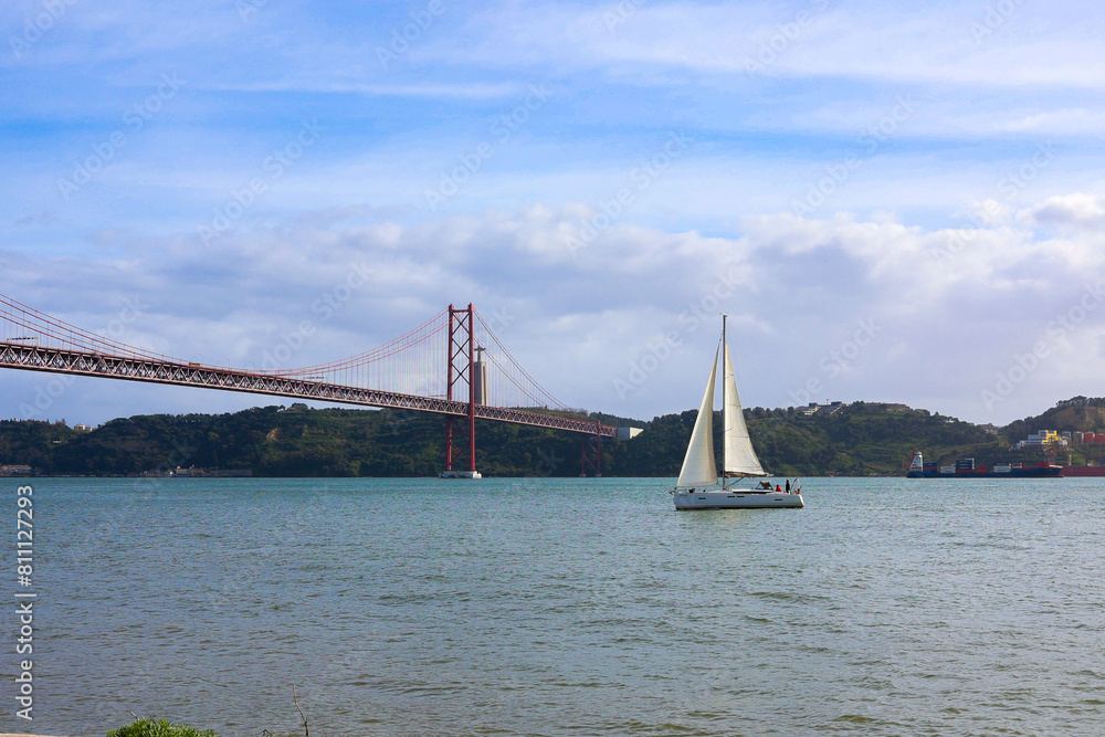 Fototapeta premium boat over the river by ponte 25 de abril of lisbon